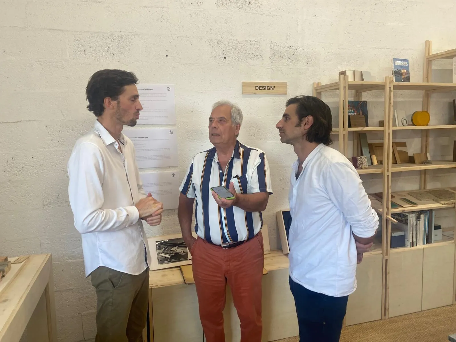 Échanges lors de l’inauguration, devant les bibliothèques en bois de l’atelier