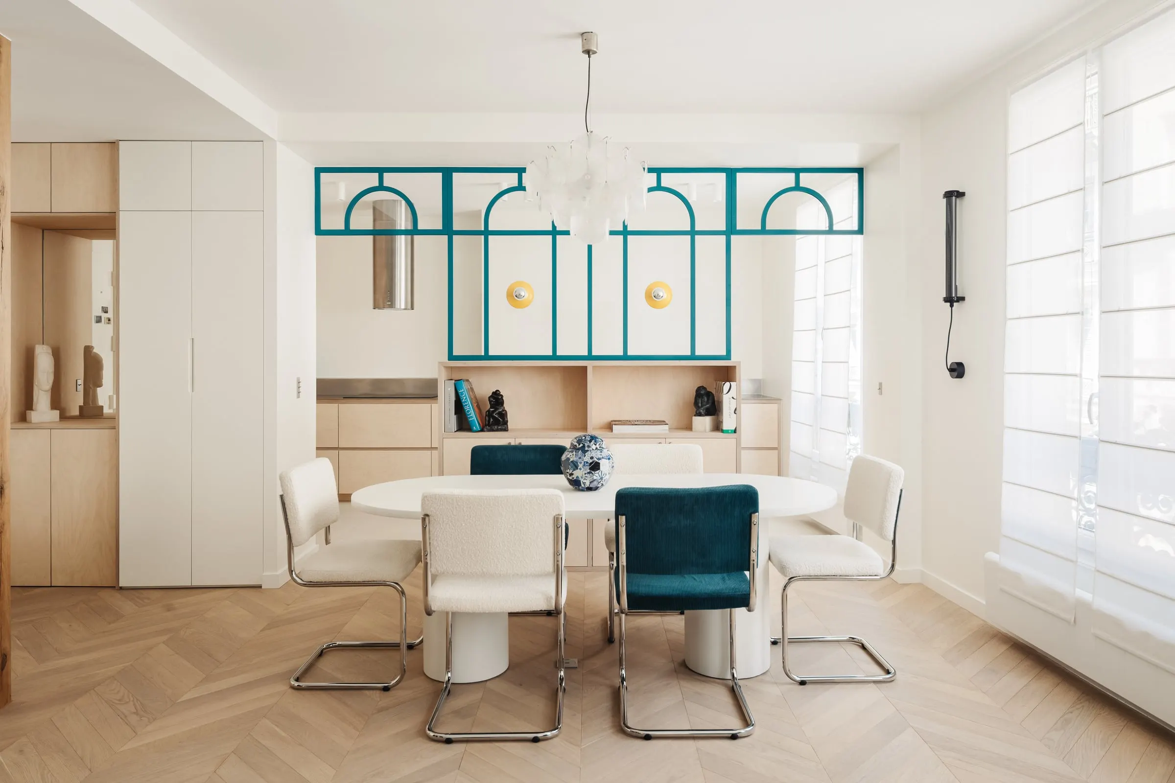Salle à manger de l’appartement Batelière et verrière bleue à motifs en demi-cercle