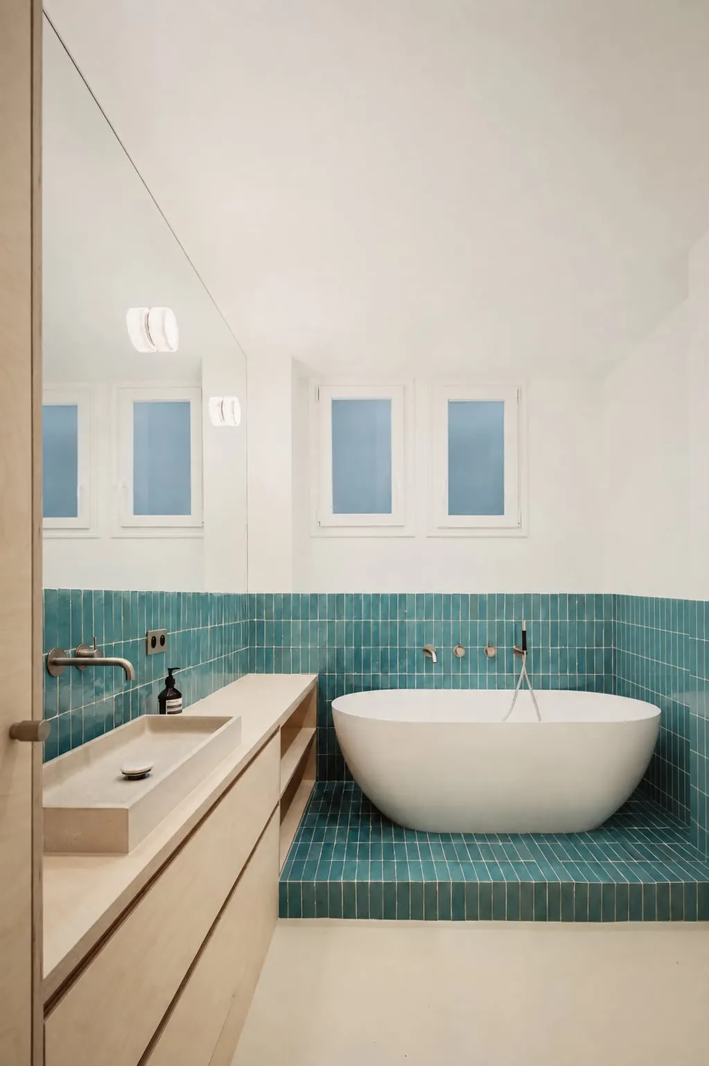 Baignoire sur podium en carrelage turquoise