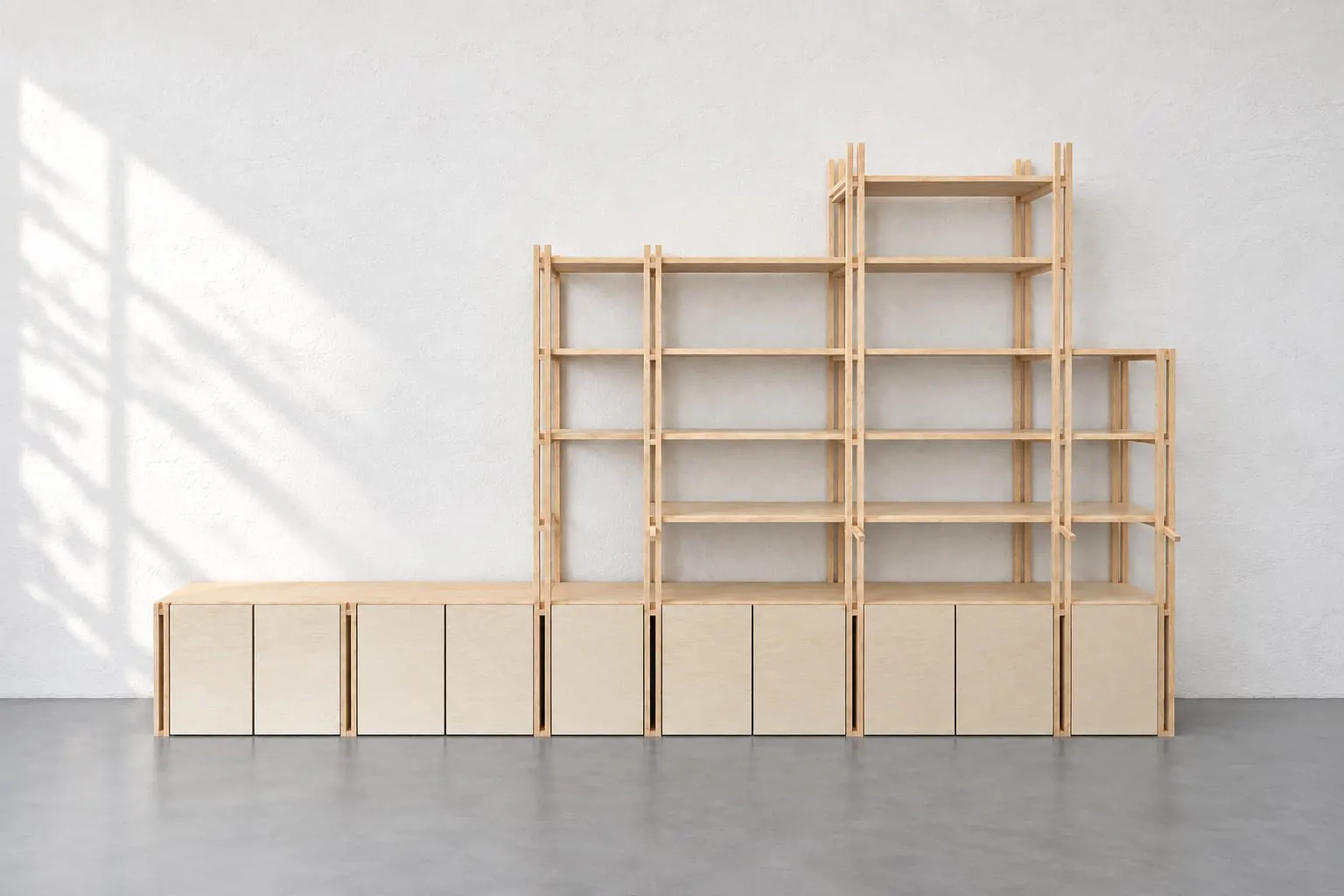 Grande bibliothèque en bois clair assemblée par moisage devant un mur blanc