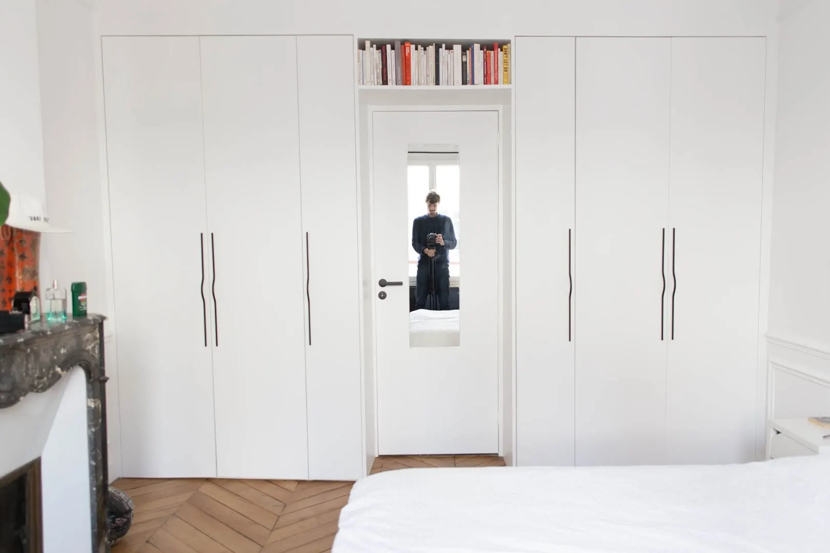 Rangements blancs toute hauteur de part et d’autre de la porte de la chambre