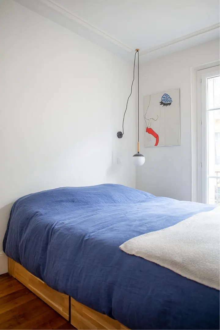 Chambre avec linge de lit bleu et suspension en verre