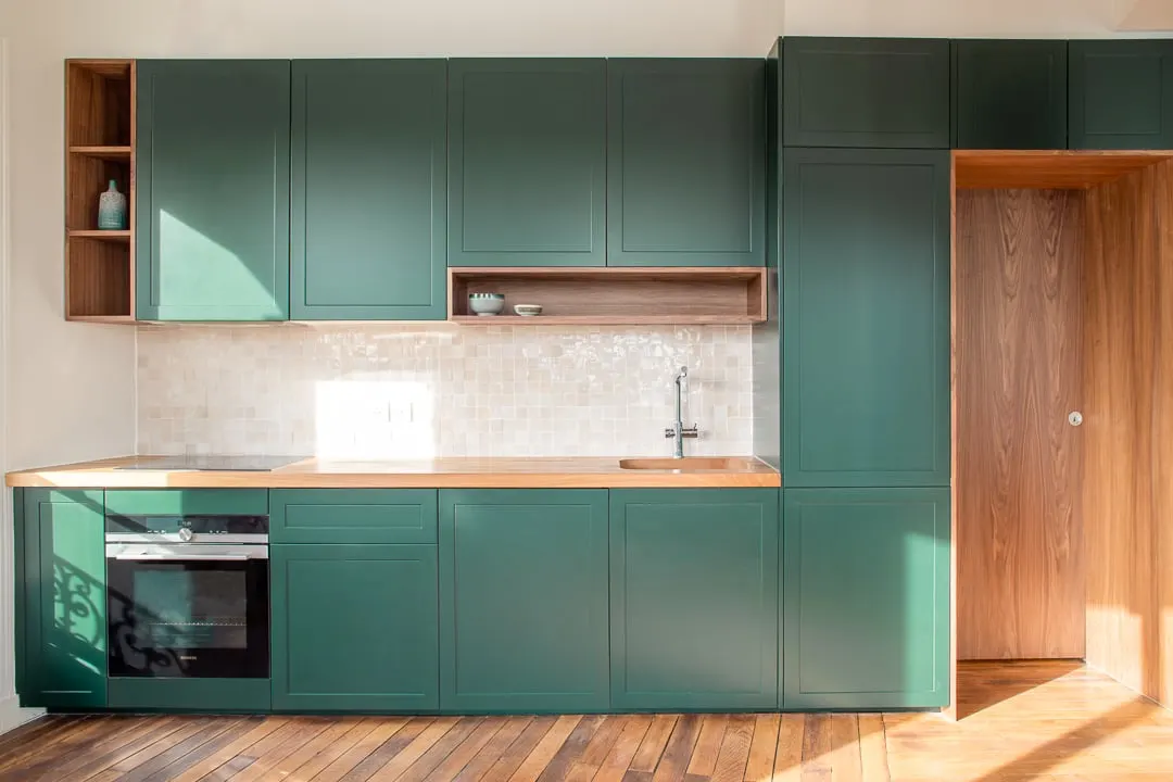 Cuisine aux façades vertes et plan de travail en bois