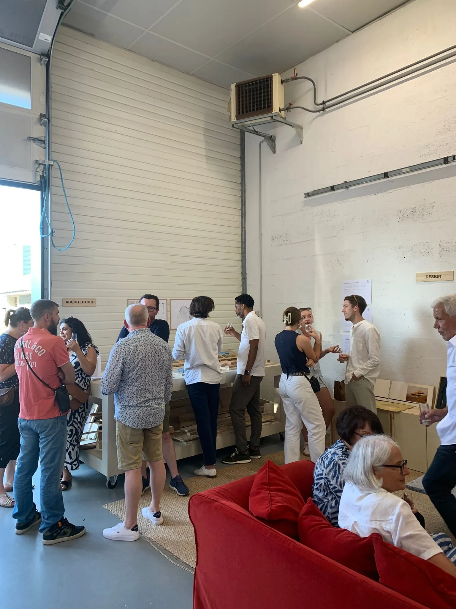 Invités réunis dans l’atelier, autour des meubles fabriqués par le studio