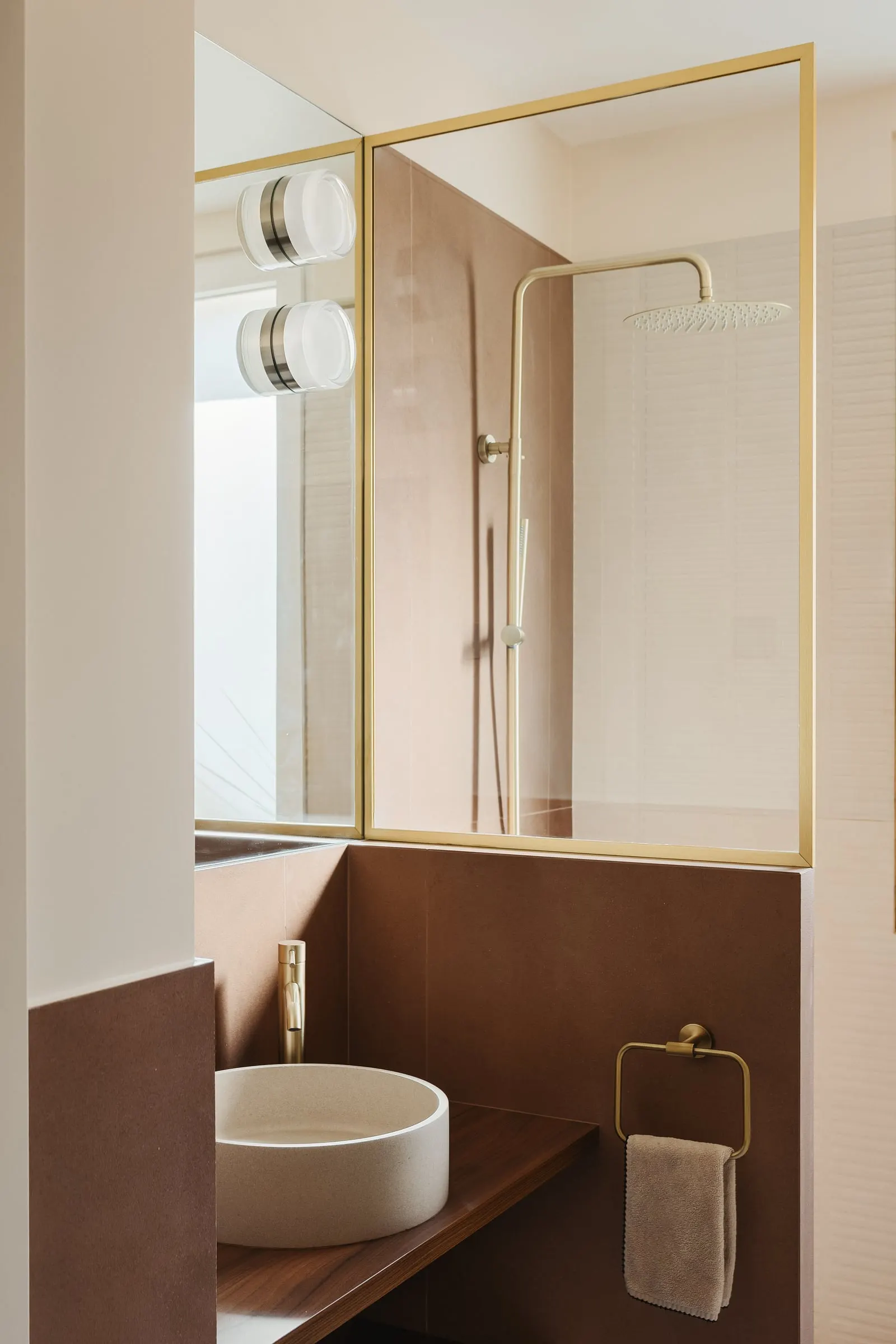 Salle d’eau aux tons terre rosée et détails dorés
