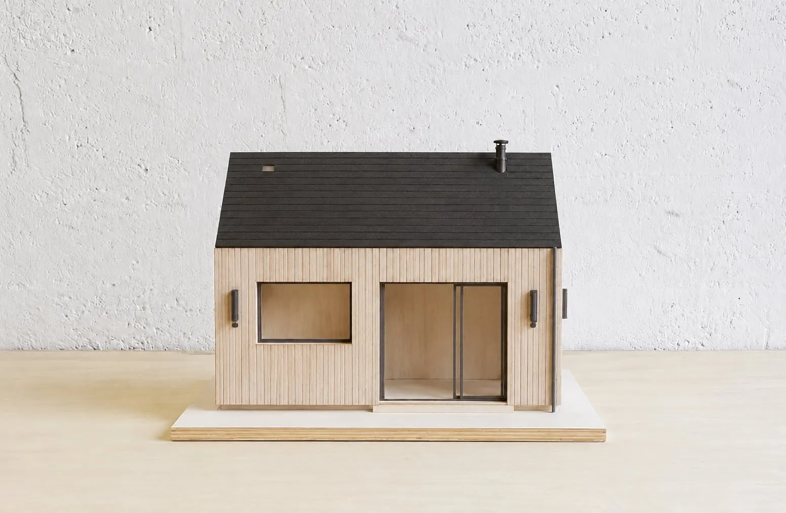 Maquette de la maison en bois clair et toiture noire