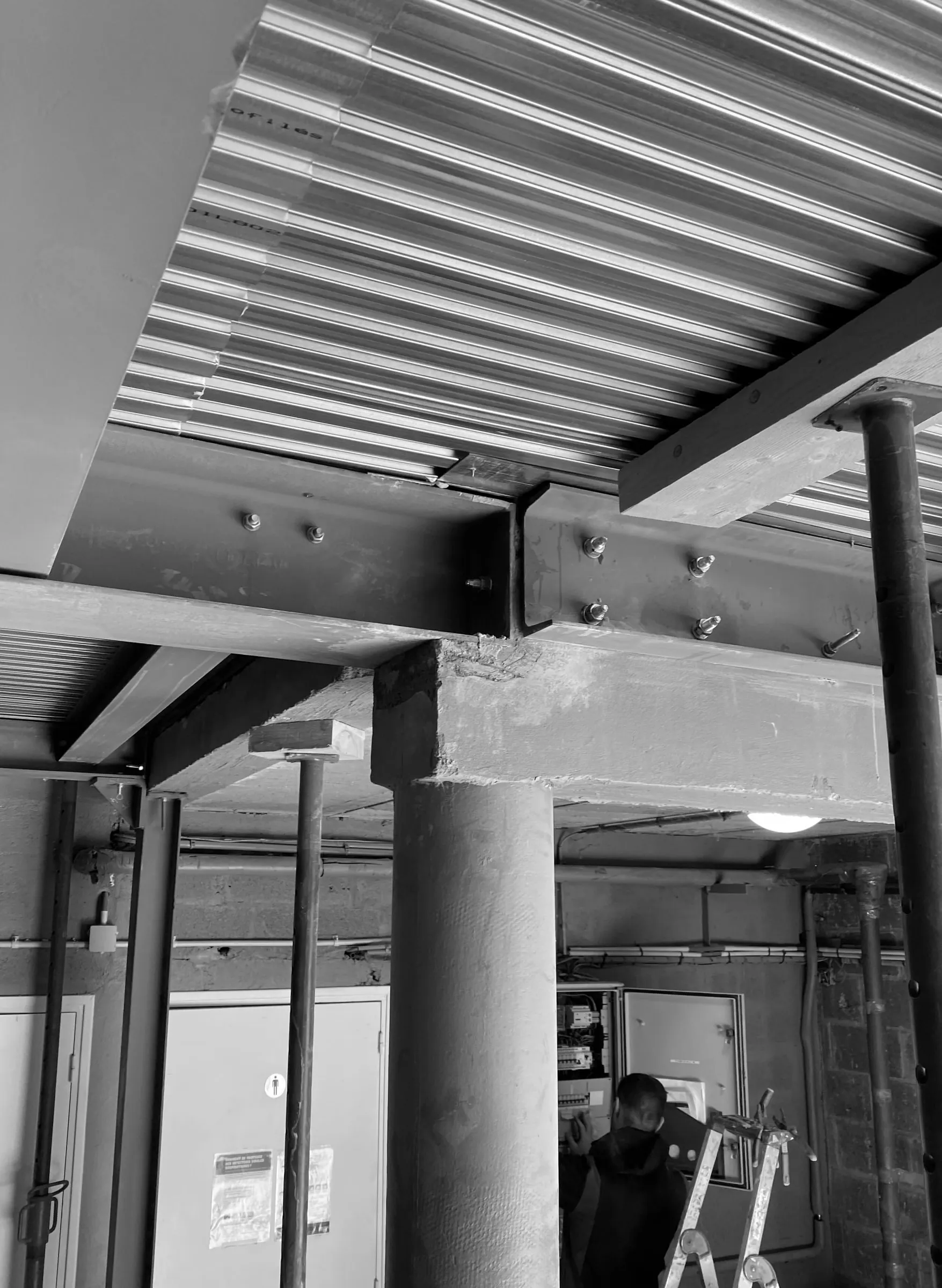 Poutre métallique boulonnée sur un poteau béton et plancher en bac acier, pendant le chantier