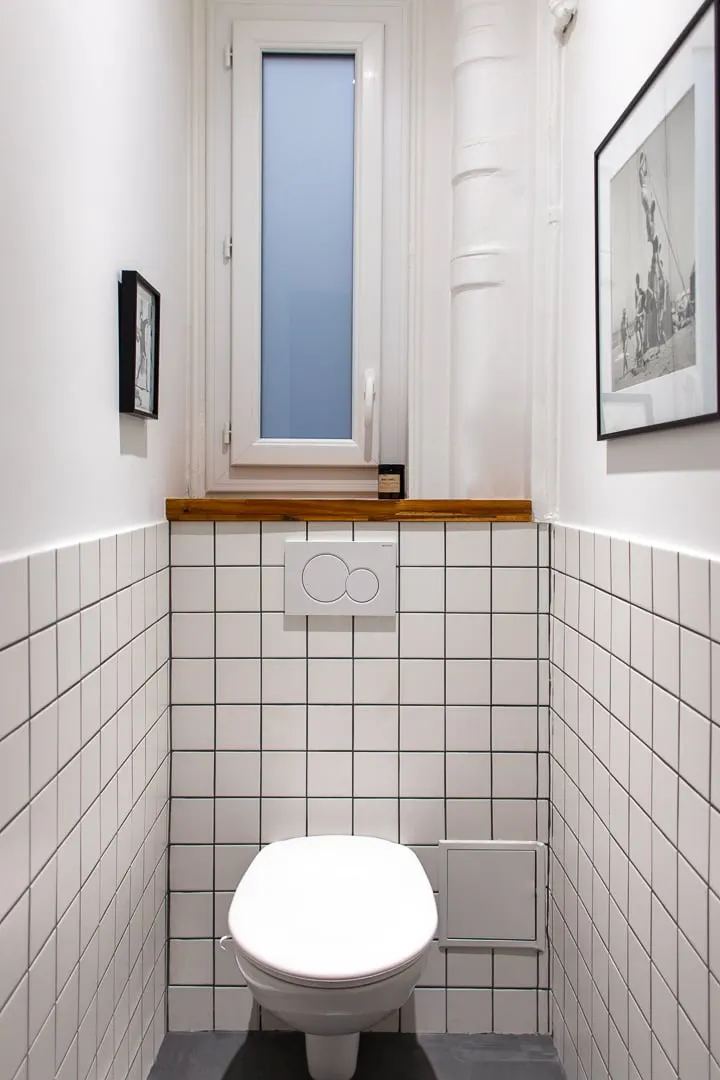Toilettes suspendues et carrelage blanc
